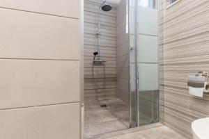 um chuveiro numa casa de banho com uma porta de vidro em City Vibes, a KalamataStay Property em Kalamata