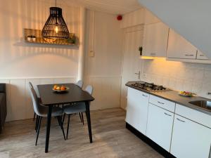 a kitchen with a black table and a table and chairs at Appartement aan het strand De Zeemeermin in Zoutelande