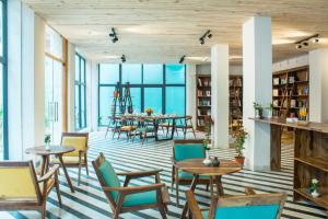 une salle avec des tables et des chaises ainsi qu'une bibliothèque dans l'établissement Brij Nest, Jaipur - An All Suite Boutique Hotel, à Jaipur