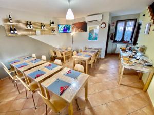 a dining room with tables and chairs and a tv at The Green Guest House in Barolo