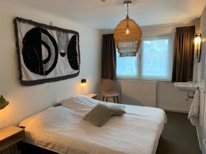 1 dormitorio con 1 cama y una pintura en la pared en Appartement aan het strand De Zeemeermin en Zoutelande