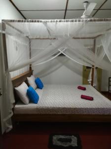 a bedroom with a bunk bed with blue and white pillows at Lasindu Guest in Ahangama