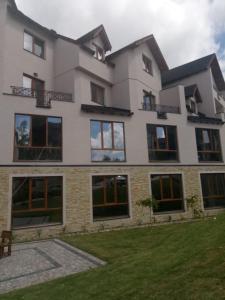 a large white building with windows and a lawn at Apartman Šilja L22 Milmari Kopaonik in Kopaonik