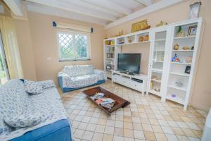 Una sala de estar con un sofá y un televisor. en villa dei limoni Etna-mare, en Acireale