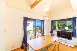 a dining room with a table and a large window at Regina Ishigaki Kabira Sky / Two-Bedroom House in Kabira