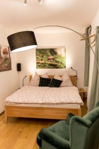 a bedroom with a bed and a green chair at Schlossberg - Apartment in Graz
