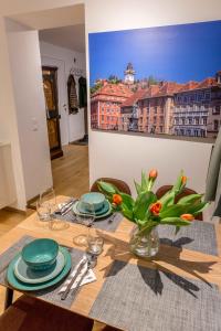 una mesa de comedor con un jarrón de flores. en Charming 45m2 Apartment in Heart of Graz, en Graz