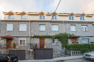 a stone house with a garage in front of it at Apartamentos turisticos Avila Villa Carmen III in Avila