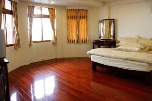 a bedroom with two beds and a wooden floor at TopHome 9 in Jiufen