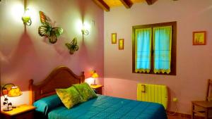 Un dormitorio con una cama azul y una ventana. en La Portilla de Cabezo, en Cabezo