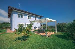 una casa blanca con una pérgola en un patio en villa dei limoni Etna-mare, en Acireale