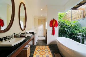 坎古的住宿－Aradhana Villas by Ekosistem，浴室配有两个盥洗盆和浴缸。