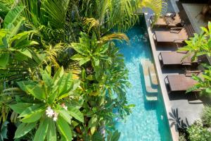 uma vista sobre uma piscina com palmeiras em Aradhana Villas by Ekosistem em Canggu