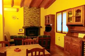 La Portilla de Cabezo في Cabezo: غرفة طعام مع طاولة ومدفأة