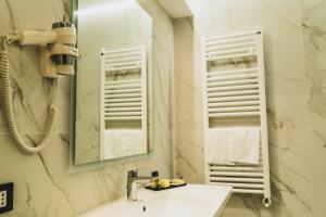 a bathroom with a sink and a mirror and towels at Hotel Pontemare in Palermo