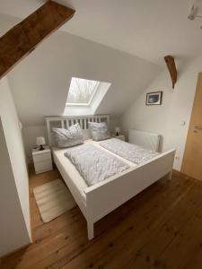 una camera da letto con letto bianco in mansarda di StorchenHof a Schmogrow