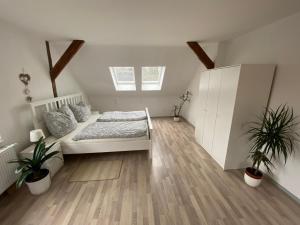 ein Schlafzimmer mit einem Bett und zwei Topfpflanzen in der Unterkunft StorchenHof in Schmogrow