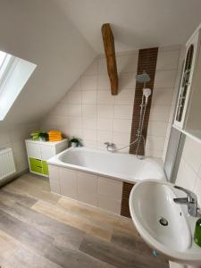 a bathroom with a white tub and a sink at StorchenHof in Schmogrow