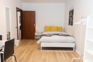 a white bedroom with a bed and a desk at Park City Center in Luxembourg