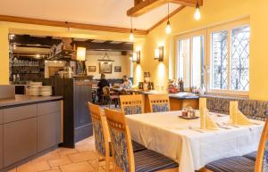 ein Restaurant mit einem Tisch und Stühlen sowie einer Küche in der Unterkunft Hotel Gasthof Stenitzer by Gastro4You in Haus im Ennstal