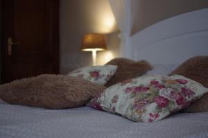 Duas almofadas e um ursinho de peluche numa cama em Villa Rusztika em Gyula