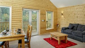 a living room with a table and a couch at Canada Lodge and Lake in Creigiau