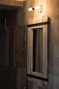 La salle de bains est pourvue d'un miroir et d'une lampe murale. dans l'établissement Captain Elias Studios 2, à Karpathos