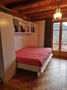 1 dormitorio con 1 cama en una habitación con ventana en Gite Montagne Mercantour, en Valdeblore