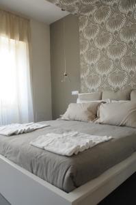 ein großes weißes Bett in einem Zimmer mit Fenster in der Unterkunft Alma Mater B&B in Rom