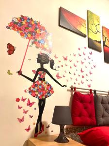um adesivo de parede de uma rapariga com um guarda-chuva e borboletas em Roma IceCream Apartment em Roma