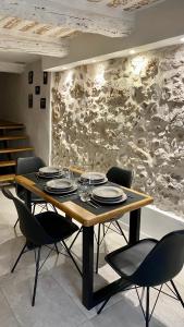 a dining room table with chairs and a stone wall at Charmant studio vieil Antibes in Antibes