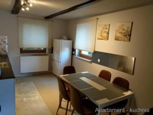 a kitchen with a table with chairs and a refrigerator at Apartamenty Martushka in Karpacz