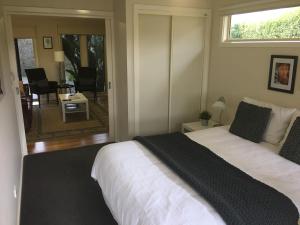 a bedroom with a large white bed with a window at Emerald Ridge in Emerald