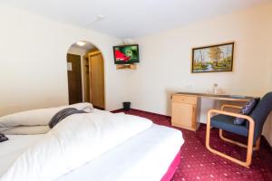 una camera d'albergo con 2 letti e una scrivania di Hotel Wiesenhof a Mieders