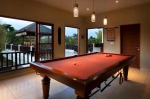 a red pool table in a room with a balcony at Puri Temple Villa in Canggu