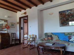 a living room with a couch and a table at Podere Erba appartamento con piscina in Cinigiano