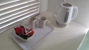 a white counter with two cups and a blender at Berg en Dal Accommodation in Saldanha