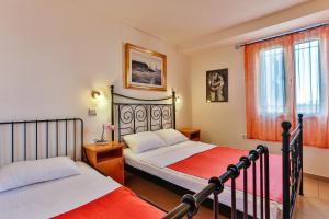 a bedroom with two beds and a window at Apartmani Luka - Vila Brzulovic in Rafailovici