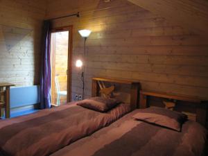 sypialnia z 2 łóżkami w drewnianym domku w obiekcie Les Myrtilles w mieście Le Bonhomme