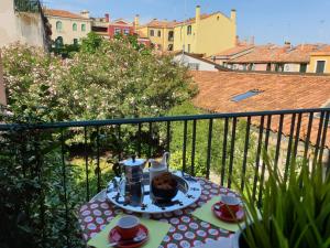 a table with a tea set on a balcony at CasaMisa Ca' Amaranta in Venice