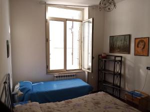 Un dormitorio con una cama azul y una ventana en The Sunny Place, en Nápoles