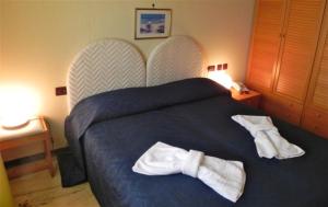 1 dormitorio con 1 cama con 2 toallas en Torreata Hotel & Residence, en Palermo