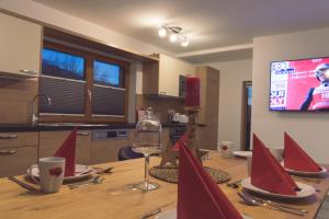 a wooden table with red napkins on top of it at Chalet am See in Aich