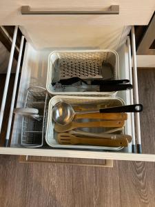 un cajón lleno de platos y utensilios en un armario en Senamiescio Tiltu apartamentai, en Klaipėda