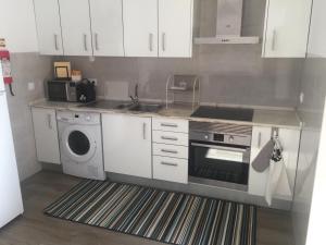 a kitchen with a stove and a washing machine at Lisboa Comfort Apartment in Lisbon