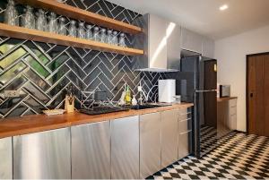 a kitchen with stainless steel cabinets and a checkered floor at The Matta in Bangkok