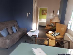 ein Wohnzimmer mit einem Sofa und 2 Stühlen in der Unterkunft Apartment Descamps in Blankenberge