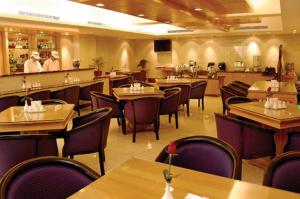 a restaurant with tables and chairs and people in the background at Kai Du Hotel in Zhongli