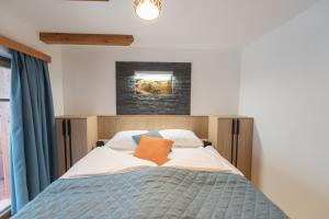 1 dormitorio con 1 cama con cortinas azules en Guesthouse Lajnar, en Zgornja Sorica