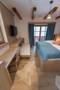 a bedroom with a bed and a desk and a tv at Guesthouse Lajnar in Zgornja Sorica